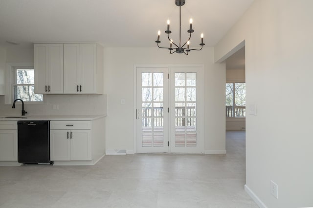 unfurnished dining area with a sink, baseboards, an inviting chandelier, and a healthy amount of sunlight