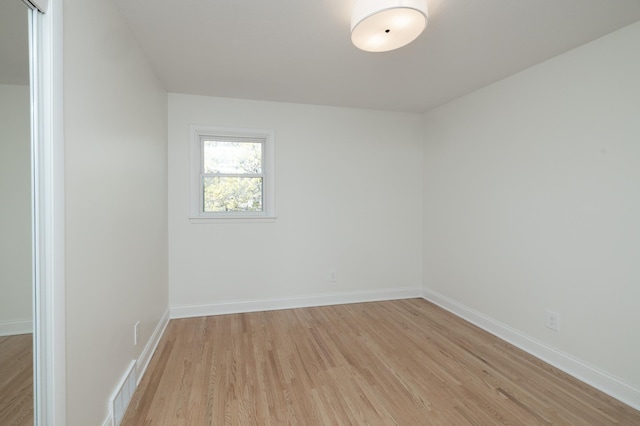 empty room featuring baseboards, visible vents, and light wood-style flooring