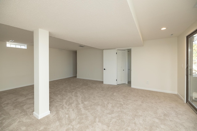 below grade area featuring recessed lighting, baseboards, and light carpet