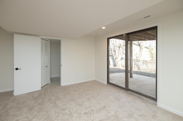 carpeted spare room featuring baseboards, recessed lighting, and visible vents