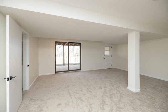 below grade area featuring baseboards and light colored carpet