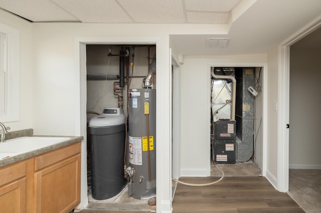 utilities featuring heating unit, a sink, and gas water heater