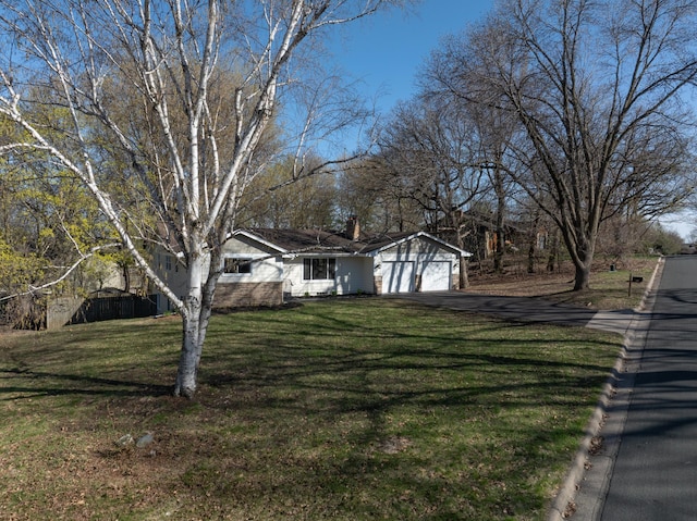 view of front facade with a chimney, a front yard, and aphalt driveway