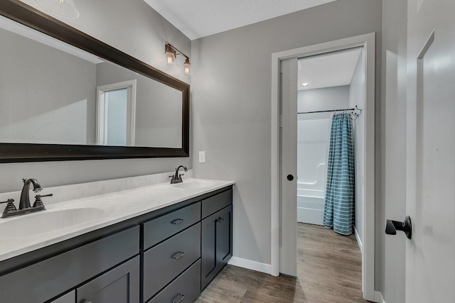 8619 State Highway 55 NW, Annandale, MN 55302 - full bathroom with double vanity, a sink, wood finished floors, and shower / tub combo with curtain