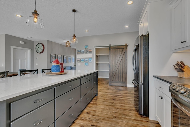 8619 State Highway 55 NW, Annandale, MN 55302 - kitchen with appliances with stainless steel finishes, hanging light fixtures, a barn door, gray cabinetry, and white cabinetry