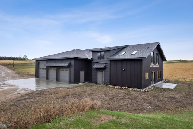 view of front of house featuring an attached garage, roof with shingles, and concrete driveway