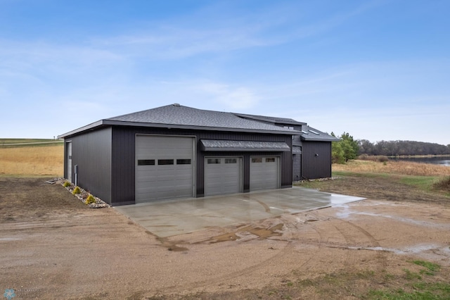 garage with roof mounted solar panels and driveway
