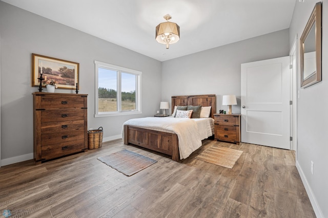 bedroom with baseboards and wood finished floors