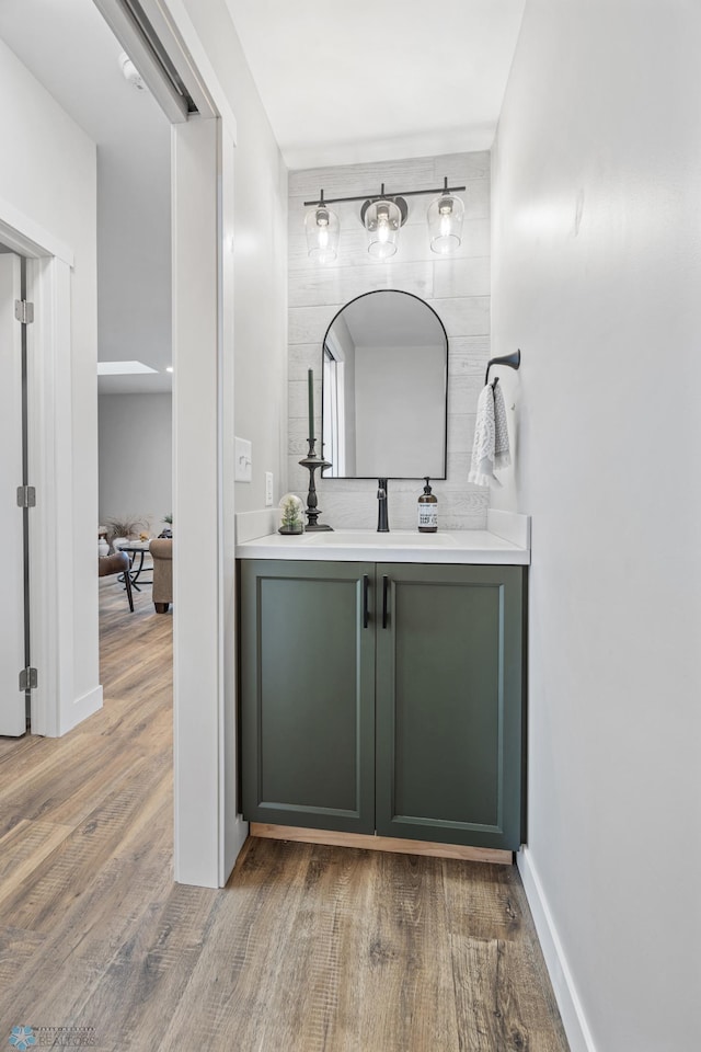 bathroom with vanity, baseboards, and wood finished floors