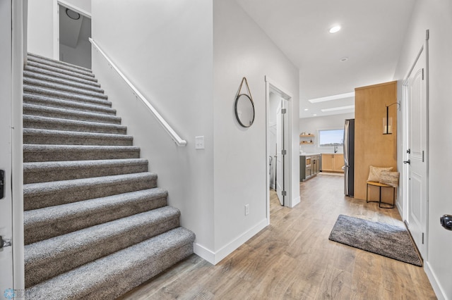 foyer entrance with baseboards, recessed lighting, stairs, and wood finished floors