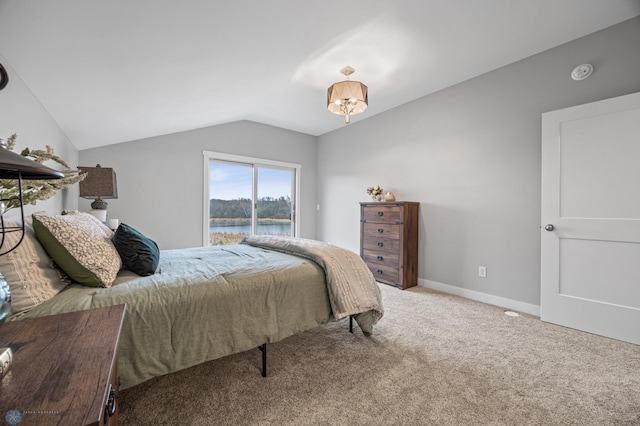 carpeted bedroom featuring baseboards, a water view, and lofted ceiling