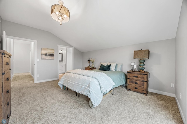 carpeted bedroom with connected bathroom, baseboards, and lofted ceiling