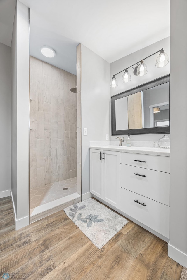 bathroom with vanity, walk in shower, and wood finished floors