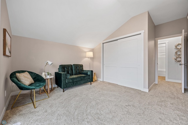 sitting room with carpet flooring, baseboards, and lofted ceiling