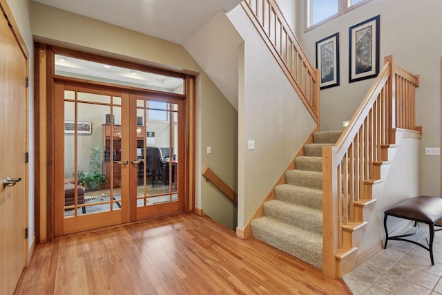 interior space featuring french doors, baseboards, wood finished floors, and stairway