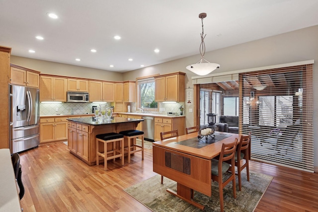 kitchen with stainless steel appliances, a center island, recessed lighting, and light brown cabinets