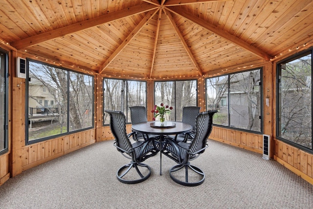 sunroom featuring carpet floors, wood walls, wooden ceiling, and a healthy amount of sunlight