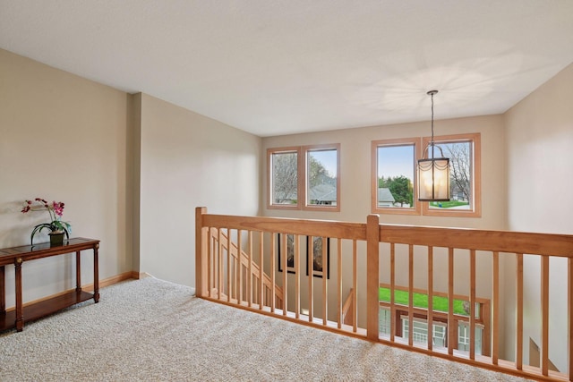hall featuring baseboards, carpet flooring, and an upstairs landing
