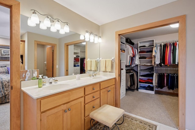 bathroom featuring double vanity, a sink, and a spacious closet