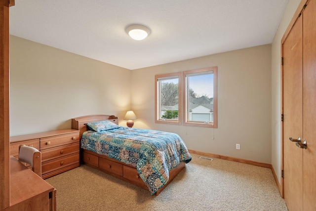 bedroom with visible vents, baseboards, and light colored carpet