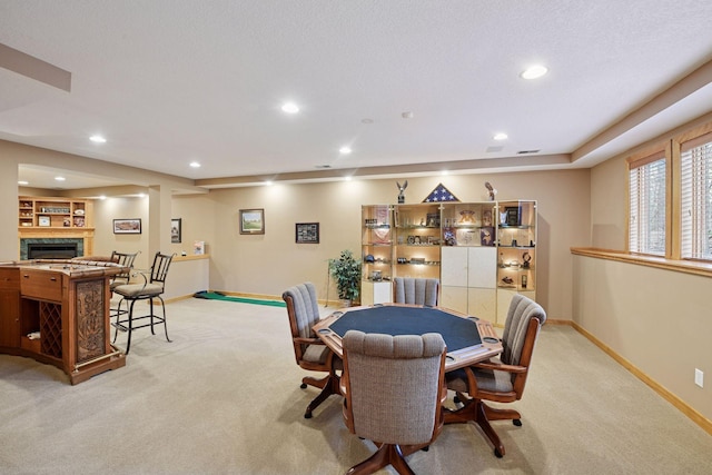 rec room featuring baseboards, recessed lighting, a glass covered fireplace, and light carpet