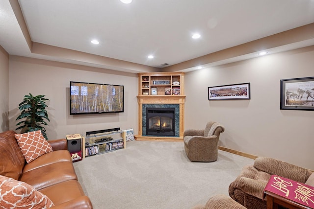 carpeted living area with recessed lighting, a high end fireplace, and baseboards