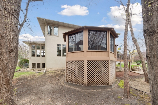 back of property featuring stucco siding and a sunroom