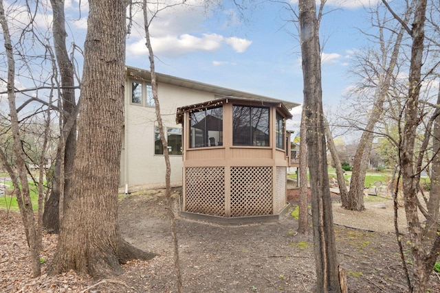 exterior space with a sunroom and stucco siding