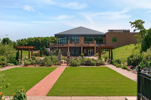 view of front of property with a pergola, a balcony, and a front lawn