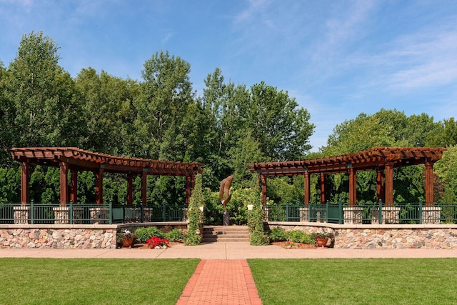 view of community with a lawn, fence, and a pergola
