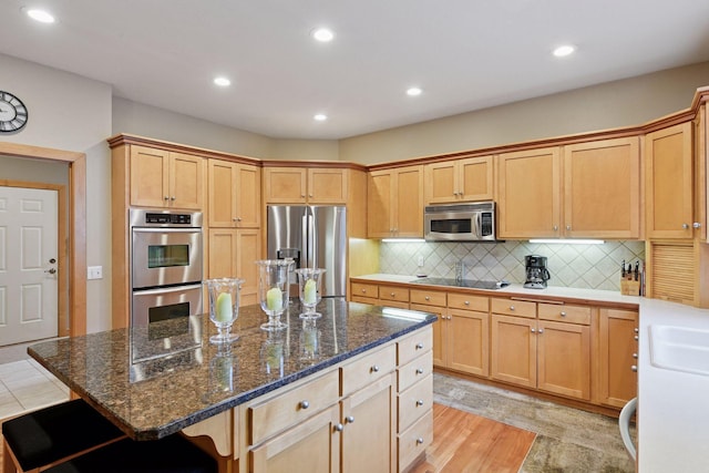 3670 Yuma Ln N, Plymouth, MN 55446 - kitchen featuring appliances with stainless steel finishes, recessed lighting, tasteful backsplash, a center island, and dark stone counters