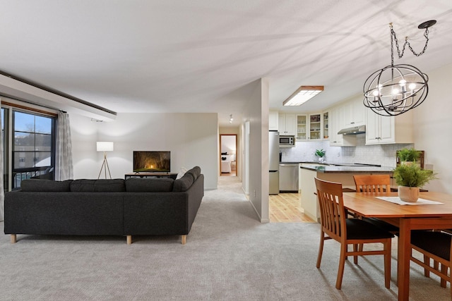 dining space with light colored carpet and a notable chandelier