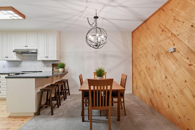 dining space featuring light colored carpet and a chandelier