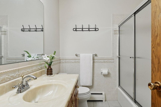 full bath featuring tile patterned flooring, a wainscoted wall, a baseboard radiator, vanity, and toilet