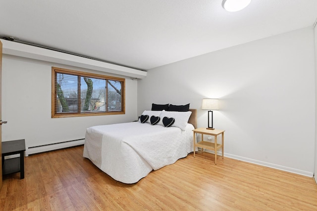 bedroom featuring baseboards, a baseboard radiator, and wood finished floors