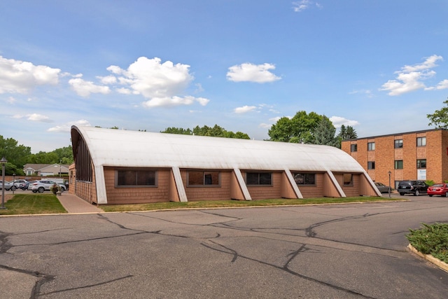 view of building exterior featuring uncovered parking