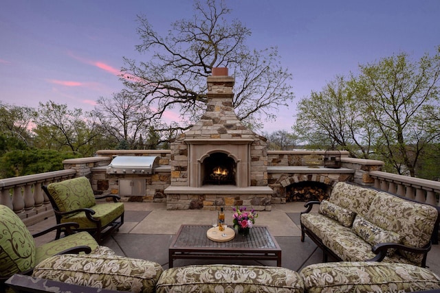 view of patio with an outdoor living space with a fireplace, area for grilling, and a grill