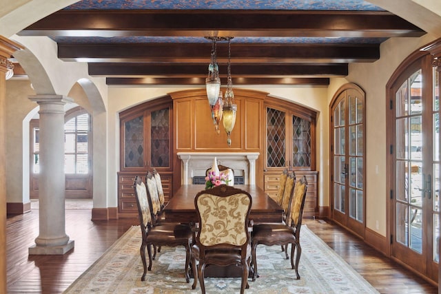 dining area with baseboards, plenty of natural light, beam ceiling, and wood finished floors
