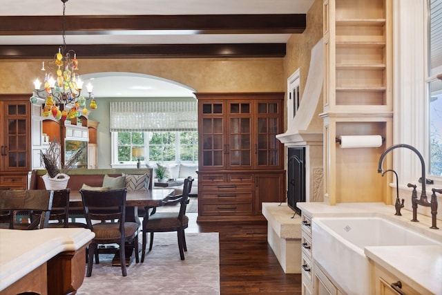 dining room with dark wood-type flooring, arched walkways, a notable chandelier, and beamed ceiling