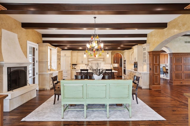 dining room featuring an inviting chandelier, arched walkways, beam ceiling, and dark wood-style floors