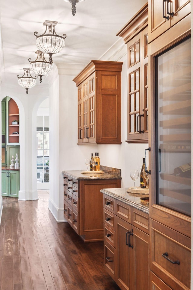 bar with crown molding, arched walkways, baseboards, and dark wood-style flooring