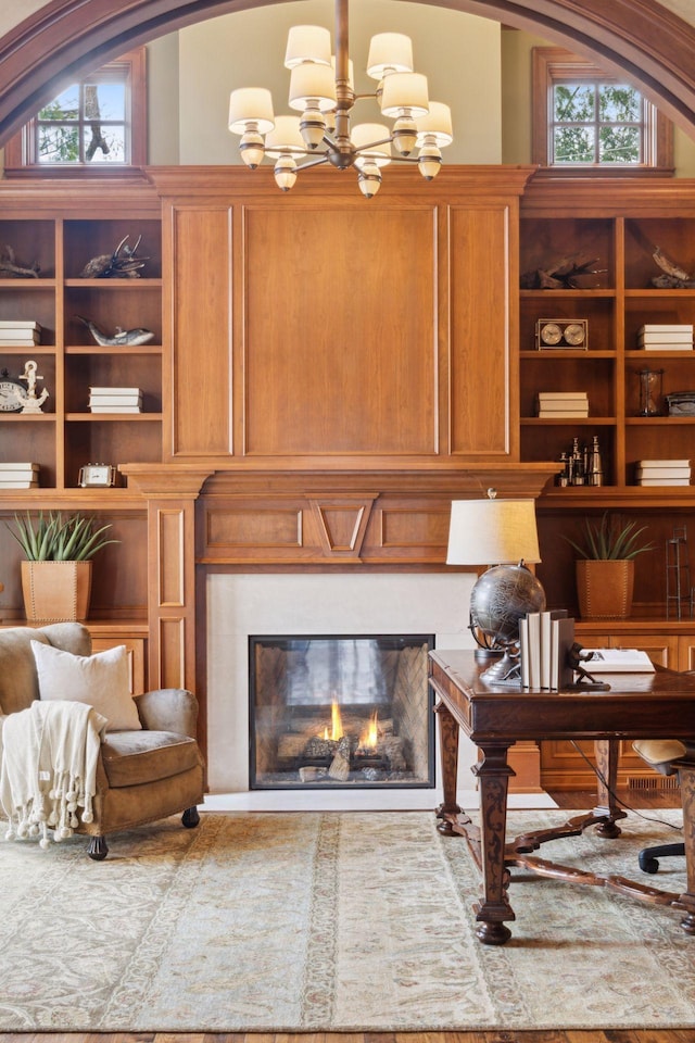 interior space with a notable chandelier, a glass covered fireplace, and plenty of natural light