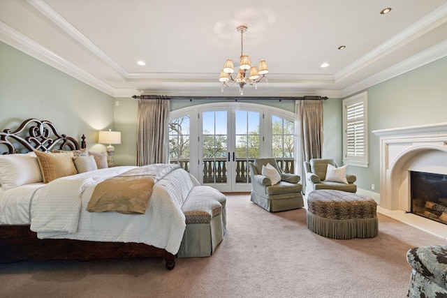 carpeted bedroom featuring access to outside, a tray ceiling, an inviting chandelier, and multiple windows