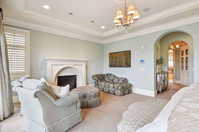 living area with arched walkways, a raised ceiling, and a chandelier