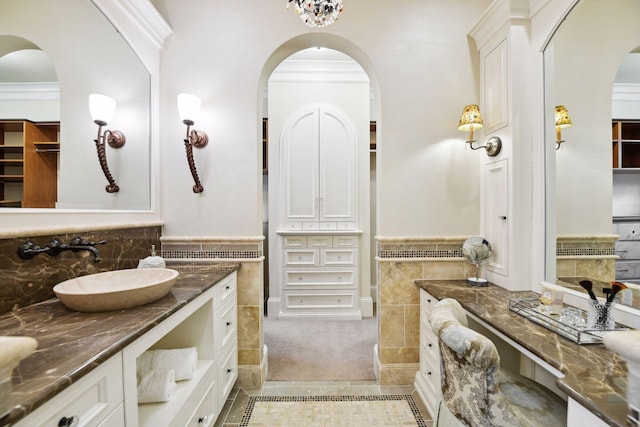 bathroom with vanity, a closet, wainscoting, tile walls, and tile patterned floors