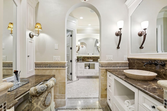 full bath with backsplash, two vanities, and a sink