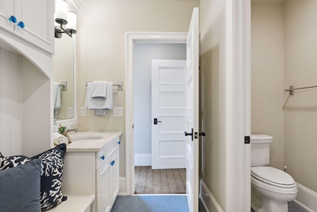 bathroom with vanity, baseboards, and toilet