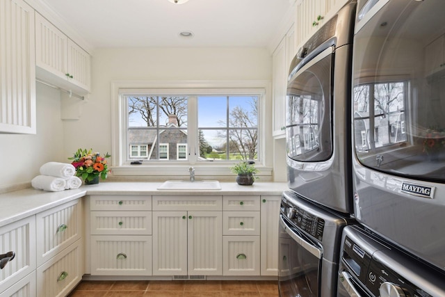 clothes washing area with visible vents, a sink, and cabinet space