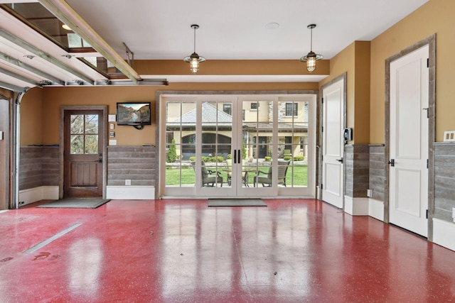 entryway featuring concrete flooring and wainscoting