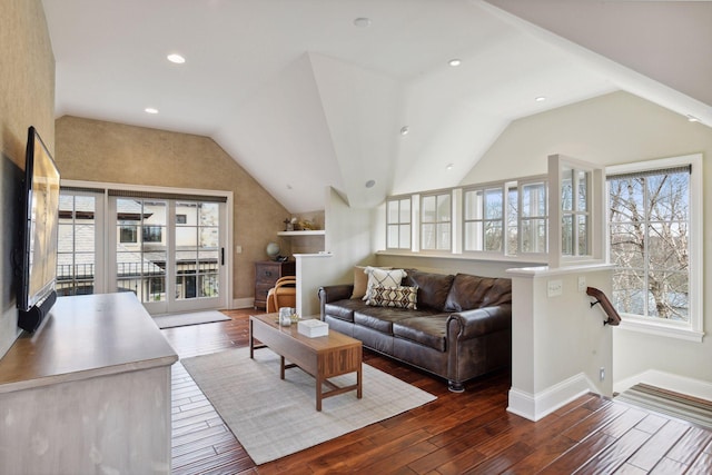 living area with plenty of natural light, wood finished floors, and lofted ceiling